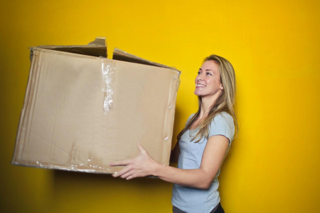 mulher segurando caixa do produto entregue por delivery